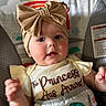 Charlotte is registered to the contest to win money with this photo: apparel, baby, bow, child, clothing, colorful, cute, expression, face, headband, indoor, infant, pattern, person, portrait, seat, sitting, smile, sun, toddler