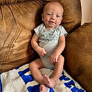 Creed is registered to the contest to win money with this photo: baby, infant, smiling, couch, blanket, indoor, child, person, comfortable, relaxed, clothing, sitting, happy, skin, foot, hand, head, blue, white, brown