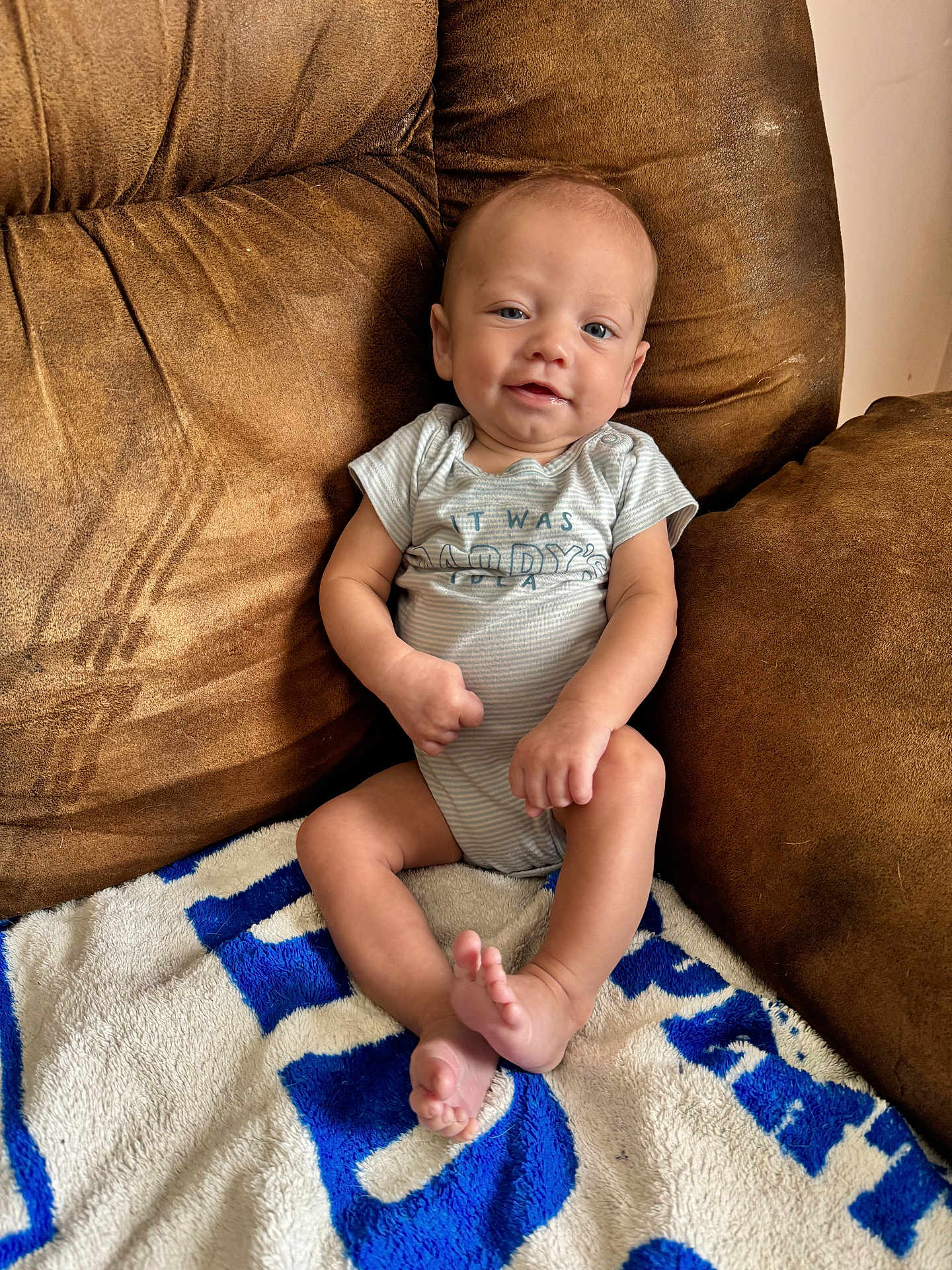 Creed is registered to the contest to win money with this photo: baby, infant, smiling, couch, blanket, indoor, child, person, comfortable, relaxed, clothing, sitting, happy, skin, foot, hand, head, blue, white, brown