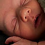 baby, newborn, sleeping, close_up, face, hand, finger, nose, mouth, eyelids, skin, blanket, soft_texture, peaceful, portrait, infant, tiny_fingers, cuddly, resting, cozy
