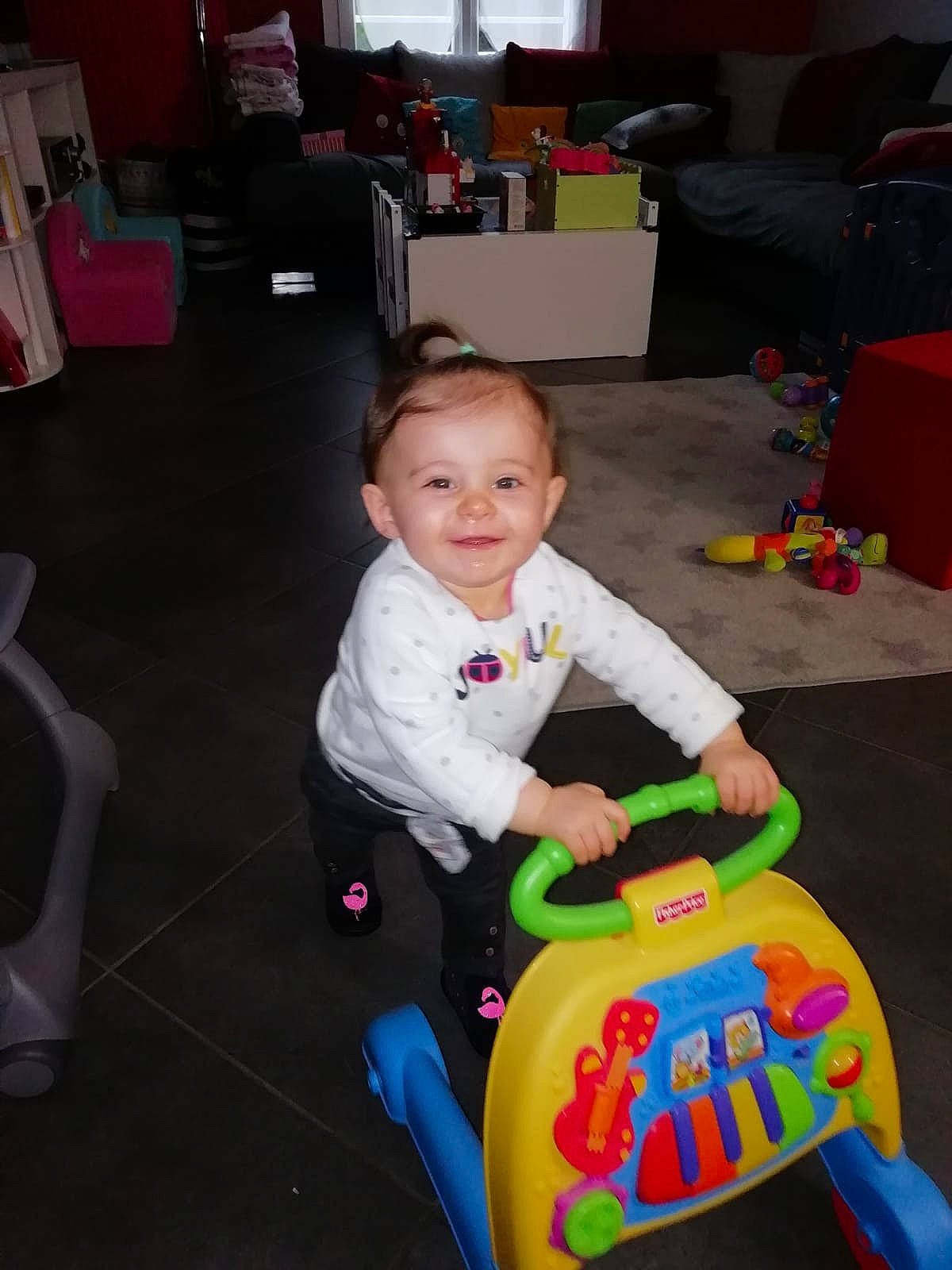 Maëlya a rejoint le concours — aidez-le/la à gagner de superbes lots ! baby, baby_playing_with_toys, baby_products, baby_toddler_clothing, baby_toys, cabinetry, child, floor, flooring, joy, lamp, living_room, person, plastic, play, riding_toy, sitting, television, toddler, toy