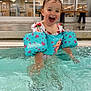 toddler, child, pool, water, floaties, swimming, splashing, indoor_pool, happy, smiling, clothing, bench, chair, face, person, playful, water_safety, fun, cute, joy
