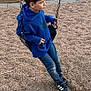 child, boy, swing, playground, blue_hoodie, jeans, sneakers, outdoor, gravel, chain, side_view, casual_clothing, daylight, young, playing, park, leisure, person, footwear, contemplative