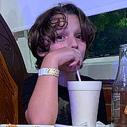 Greycen joined the competition — help win amazing prizes! black_shirt, bottle, boy, casual, child, cup, curly_hair, drink, drinkware, face, food, indoor, person, pizza, restaurant, sitting, straw, table, window, wristband