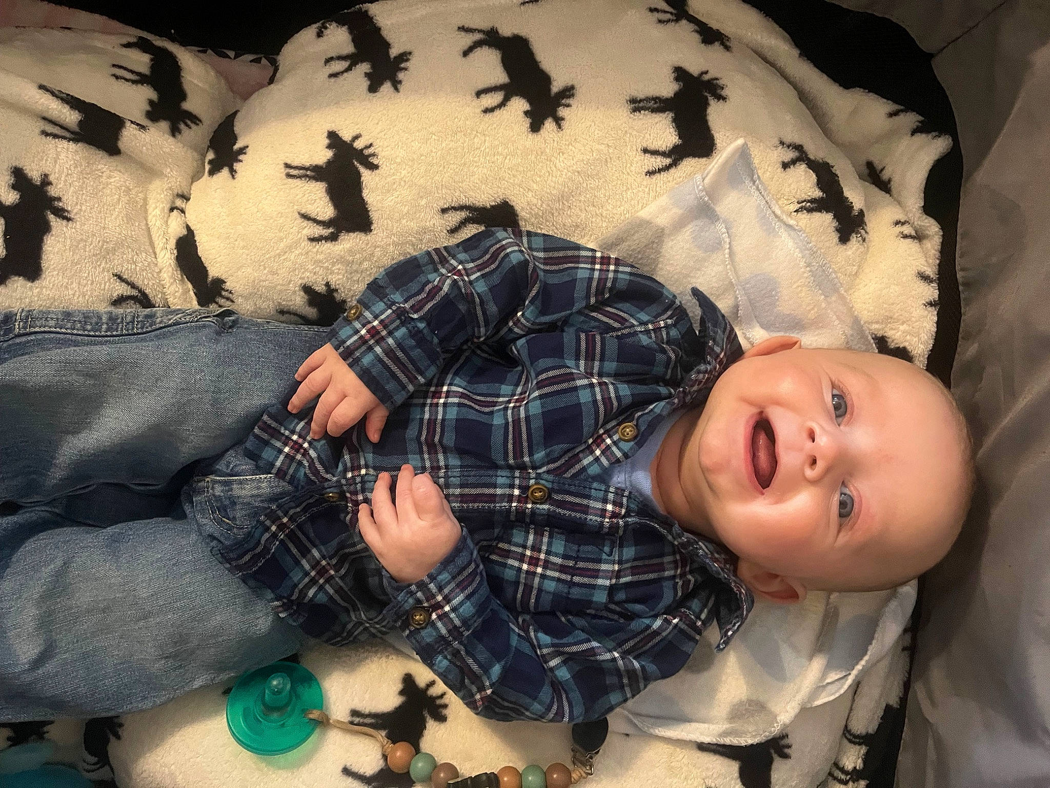 Ezekiel is registered to the contest to win money with this photo: black_hair, child, design, dress, flash_photography, gesture, happy, human, leaf, mouth, pattern, person, plaid, plant, sitting, smile, tartan, textile, toddler, toy