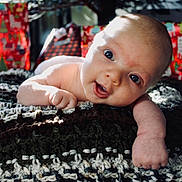 Atlas joined the competition — help win amazing prizes! baby, infant, blanket, knitted, present, gift, wrapped, face, head, arm, skin, expression, eyes, mouth, indoors, cozy, holiday, festive, soft_light, portrait