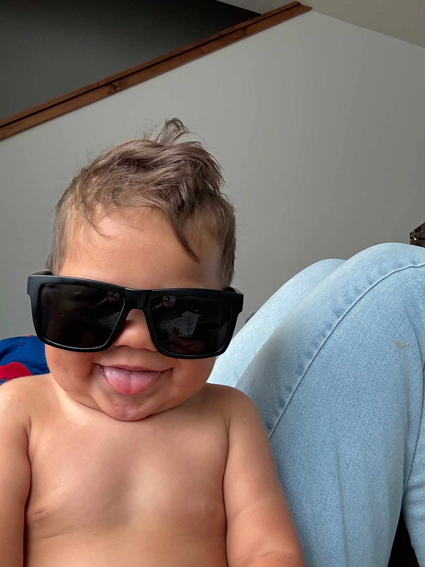Duck is registered to the contest to win money with this photo: toddler, child, sunglasses, tongue_out, shirtless, smile, hair, indoor, legs, jeans, light_background, cute, happy, person, portrait, skin, playful, funny_expression, casual, young_child