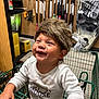 child, toddler, shopping_cart, furry_hat, smiling, indoor, store, tools, boxes, clothing, happy, baby, face, person, retail, shelf, cute, fun, young_child, casual
