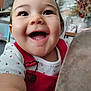arm, baby, background, child, closeup, cute, decor, face, happy, heart_pattern, home, indoor, infant, joy, person, plant, portrait, red_clothing, smiling, white_shirt