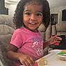 child, couch, curly_hair, cute, food, fruit, hand, happy, high_chair, indoor, living_room, mealtime, person, pink_shirt, portrait, smiling, sofa, table, toddler, watermelon