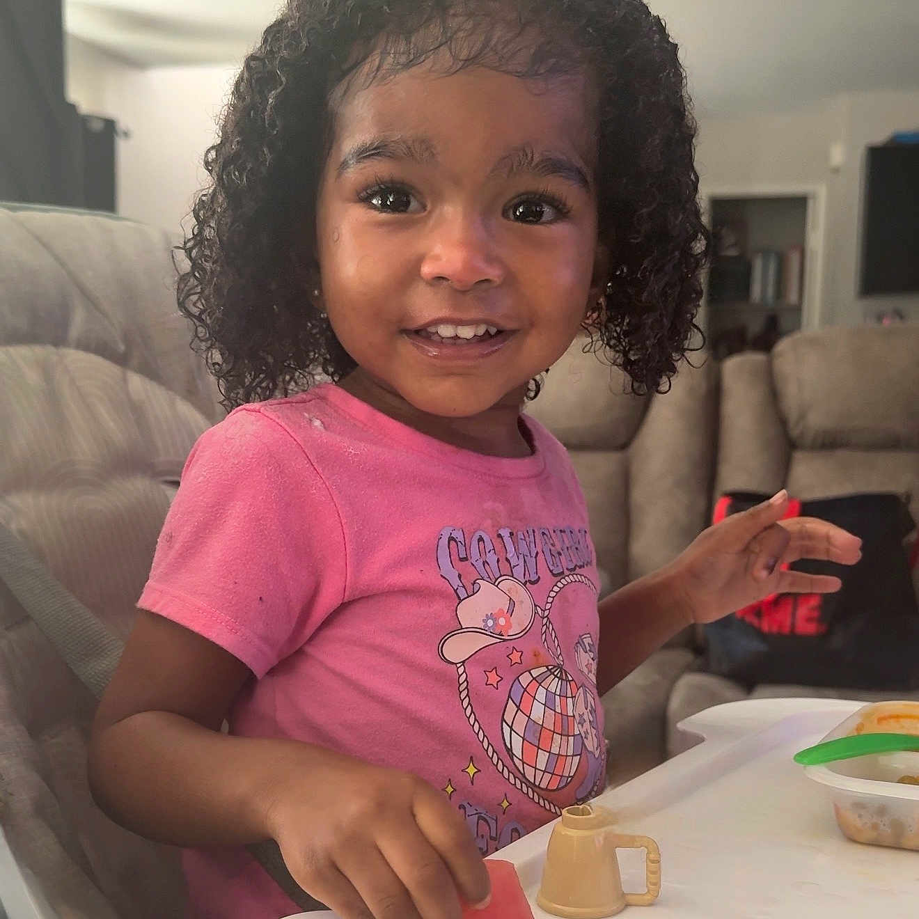 Nami joined the competition — help win amazing prizes! child, couch, curly_hair, cute, food, fruit, hand, happy, high_chair, indoor, living_room, mealtime, person, pink_shirt, portrait, smiling, sofa, table, toddler, watermelon