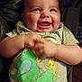 baby, infant, smiling, laughing, onesie, clothing_print, green, cartoon_print, chubby_cheeks, hands, sitting, car_seat, fabric, indoor, closeup, portrait, adorable, happy, person, cute