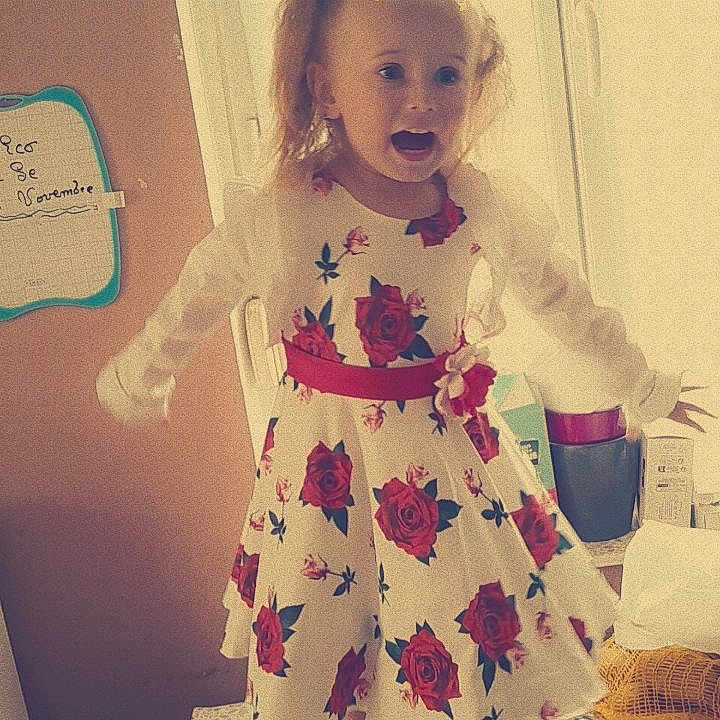 Lyana participe au concours pour gagner de l'argent avec cette photo : child, girl, dress, flowers, roses, table, standing, arms_outstretched, open_mouth, playful, window, light, indoor, home, calendar, digital_crown, stars, moons, sandals, happy