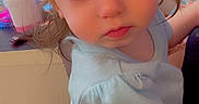 Adalynn joined the competition — help win amazing prizes! toddler, child, baby, blue_eyes, light_blue_shirt, dark_shorts, indoor, person, curious_expression, close_up, sitting, lap, hair, young_child, cute, face, hand, furniture, background, household_items