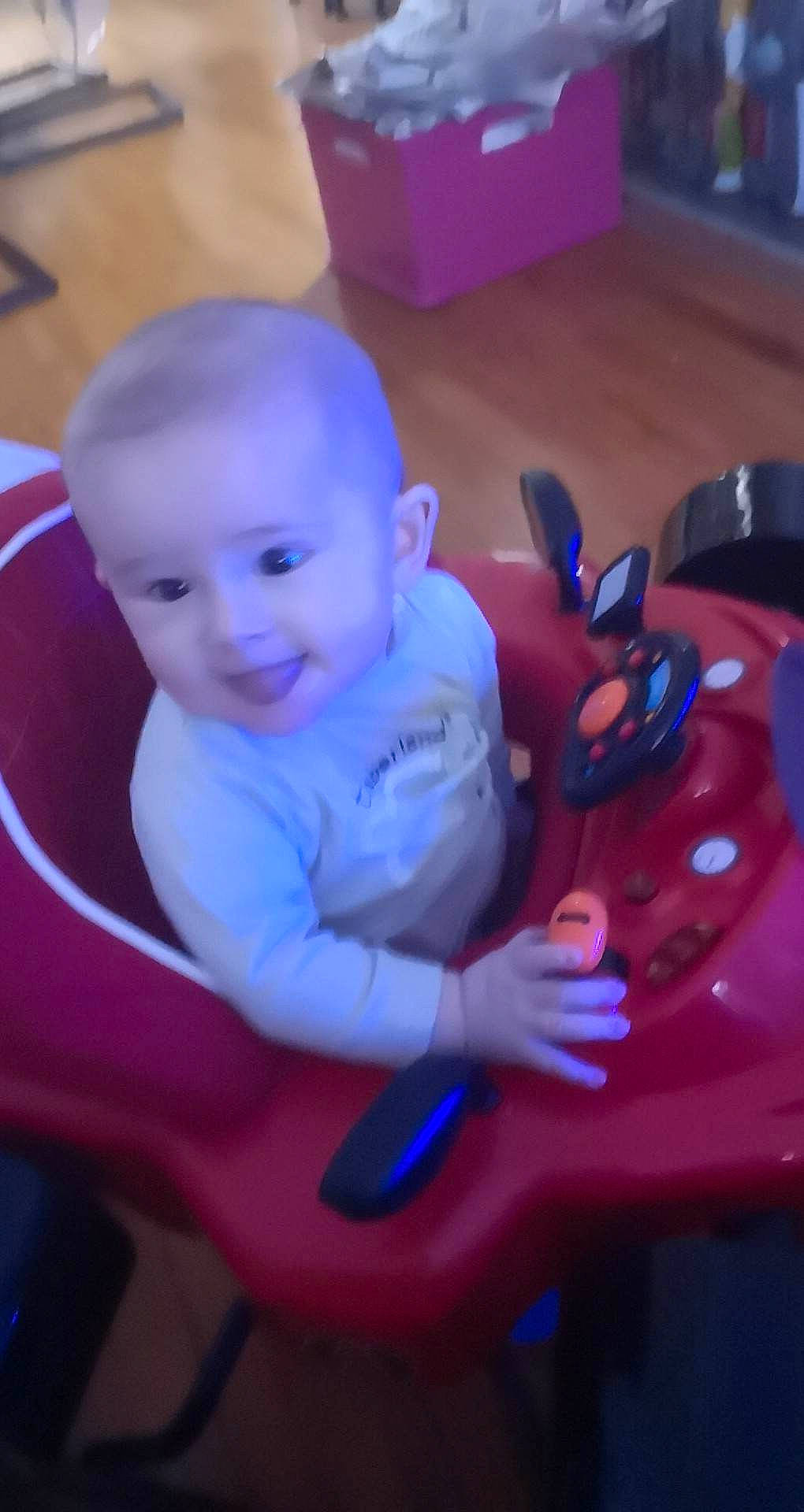 Michel participe au concours pour gagner de l'argent avec cette photo : baby, baby_products, baby_toddler_clothing, baby_toys, carmine, chair, cheek, child, electric_blue, fun, joy, magenta, person, pink, play, purple, riding_toy, sitting, smile, toddler