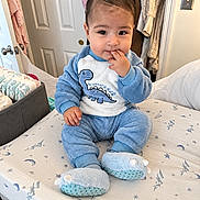 Ethan joined the competition — help win amazing prizes! baby, child, dinosaur_outfit, blue_clothing, sitting, bed, bedroom, portrait, face, smiling, hand_to_mouth, infant, pajamas, slippers, blanket, bedding, closet, indoor, cozy, family_photo
