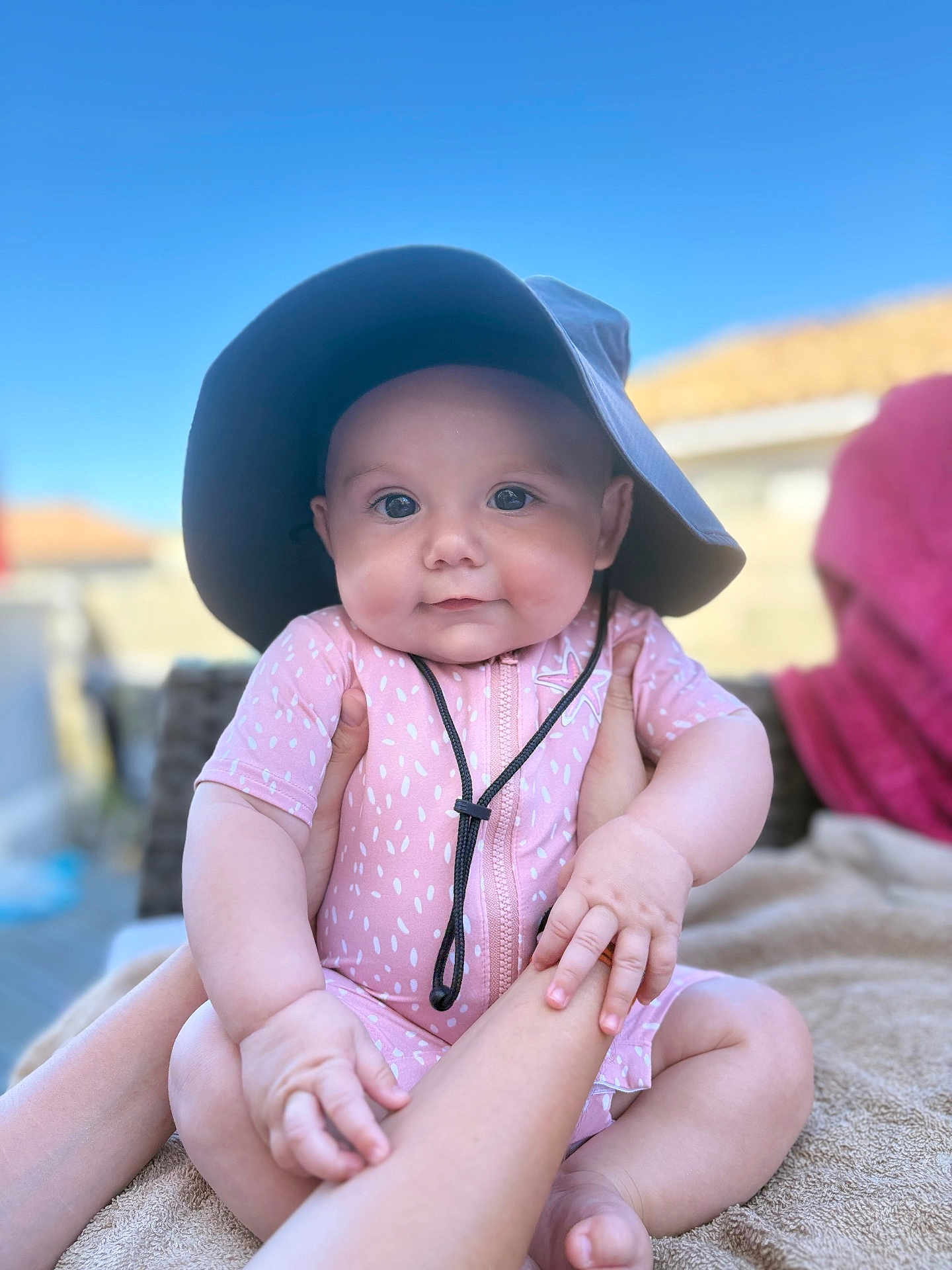 Inaya participe au concours pour gagner de l'argent avec cette photo : baby, child, infant, pink_outfit, sunhat, hands, outdoor, blue_sky, portrait, cute, smile, chubby_cheeks, sitting, soft_light, daylight, human, skin, person, closeup, photography