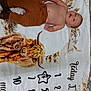 Westley joined the competition — help win amazing prizes! baby, child, milestone_blanket, brown_pants, boots, face, smiling, lying_down, animal_illustration, buffalo, floral_pattern, months, celebration, cute, indoors, blanket, skin, head, arm, hand