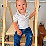 barefoot, blue_jeans, child, cute, furniture, happy, home, indoor, jeans, natural_light, person, play, polo_shirt, sitting, smile, toddler, white_shirt, window, wooden_play_structure, young_child