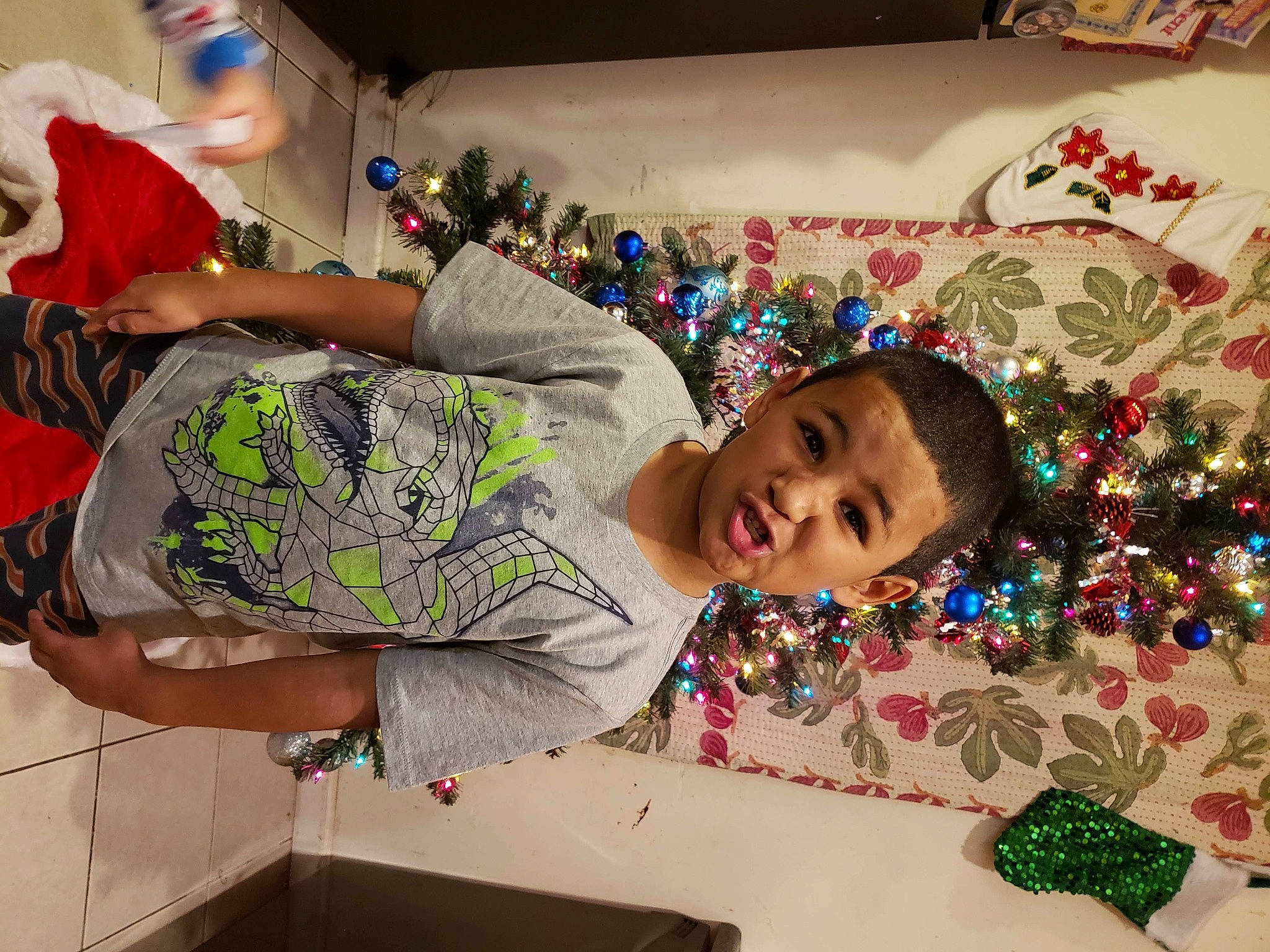 Jordan is registered to the contest to win money with this photo: child, christmas, christmas_eve, christmas_ornament, christmas_tree, event, fun, holiday, interior_design, person, plant, play, room, textile, toddler, tree