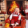baby, child, fireplace, christmas, holiday, red_clothing, plaid, armchair, smiling, toy, reindeer_toy, decorations, cozy, festive, indoor, carpet, warmth, cute, cheerful, portrait