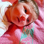 Maxime a rejoint le concours — aidez-le/la à gagner de superbes lots ! baby, child, close_up, expression, face, head, indoor, infant, lying_down, newborn, person, pink, portrait, resting, skin, soft_texture, towel, warm_lighting, white_clothing, young_child