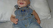 John is registered to the contest to win money with this photo: baby, bed, cap, casual, child, clothing, comfortable, cute, footwear, happy, indoors, infant, nike, overalls, person, pillow, portrait, relaxing, smiling, sneakers