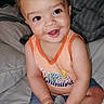 John joined the competition — help win amazing prizes! toddler, child, smiling, sitting, bed, orange_shirt, shorts, sock, foot, hands, happy, indoors, portrait, baby, cute, youth, person, face, skin, hair