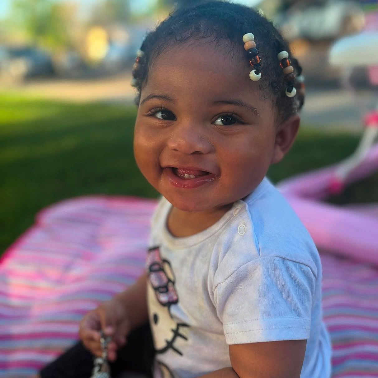 Ila-Rae is registered to the contest to win money with this photo: accessories, baby, babylaughing, bodypart, child, clothing, face, female, girl, grass, handcuffs, happy, head, person, photography, plant, portrait, sitting, smile, t_shirt