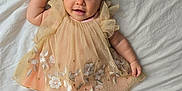 Isabella joined the competition — help win amazing prizes! baby, infant, smile, dress, headband, flower, embroidery, lying_down, happy, cute, child, soft_light, fabric, bed, skin, portrait, person, indoors, adorable, young_child