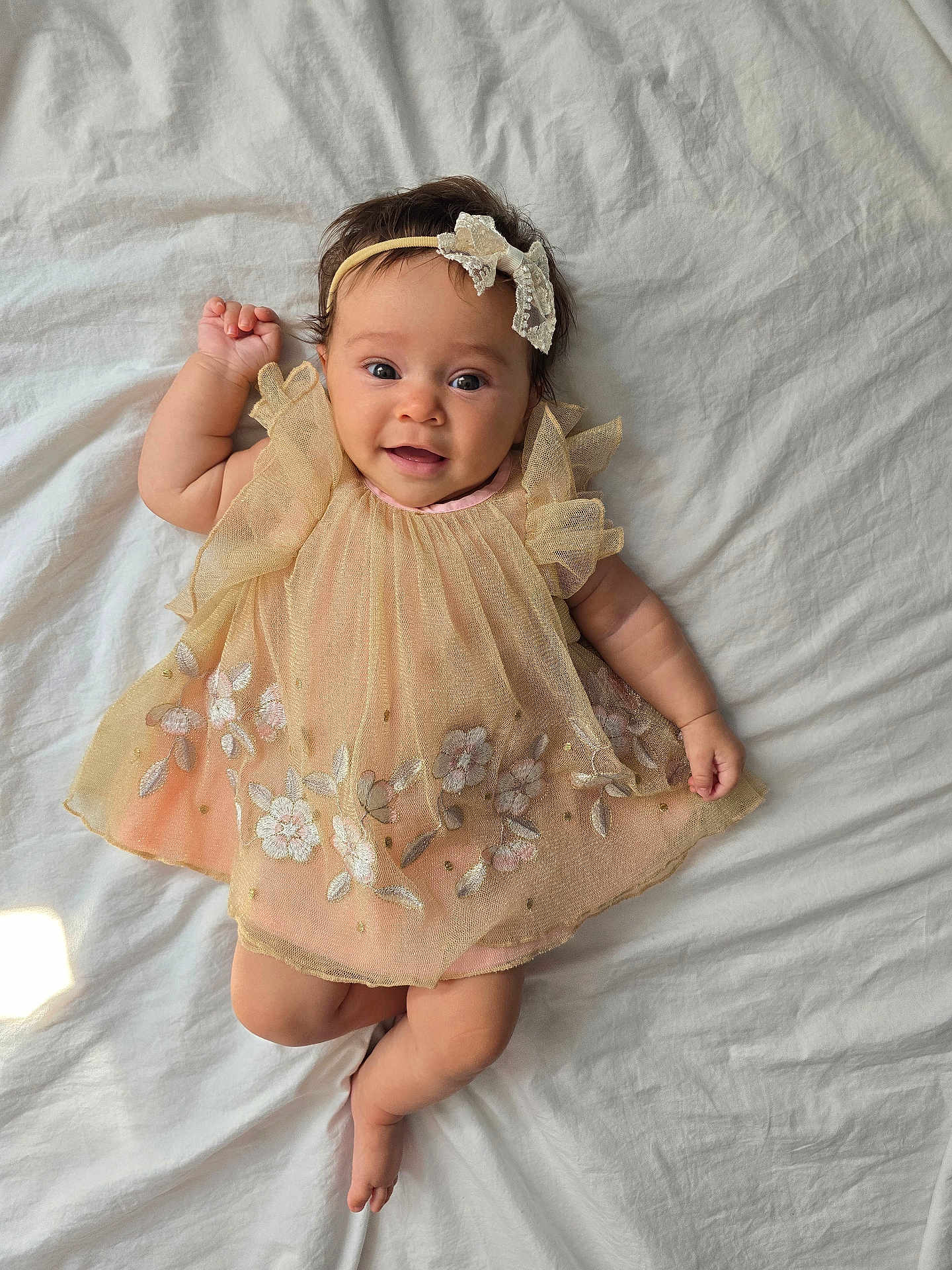 Isabella joined the competition — help win amazing prizes! baby, infant, smile, dress, headband, flower, embroidery, lying_down, happy, cute, child, soft_light, fabric, bed, skin, portrait, person, indoors, adorable, young_child