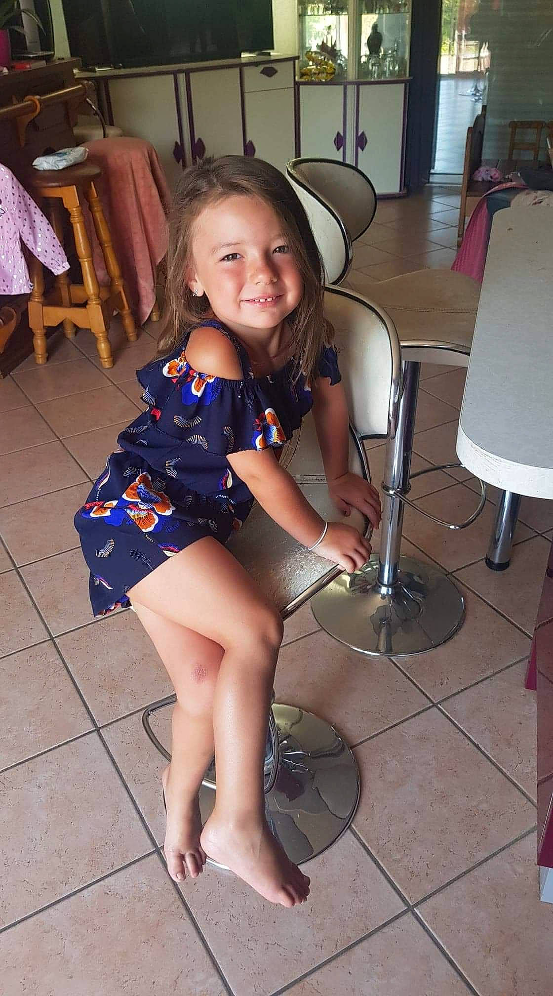 Romy participe au concours pour gagner de l'argent avec cette photo : ankle, calf, chair, day_dress, floor, flooring, foot, human_leg, joy, lamp, living_room, one_piece_garment, person, room, sitting, thigh, tile, tile_flooring, toe, trunk