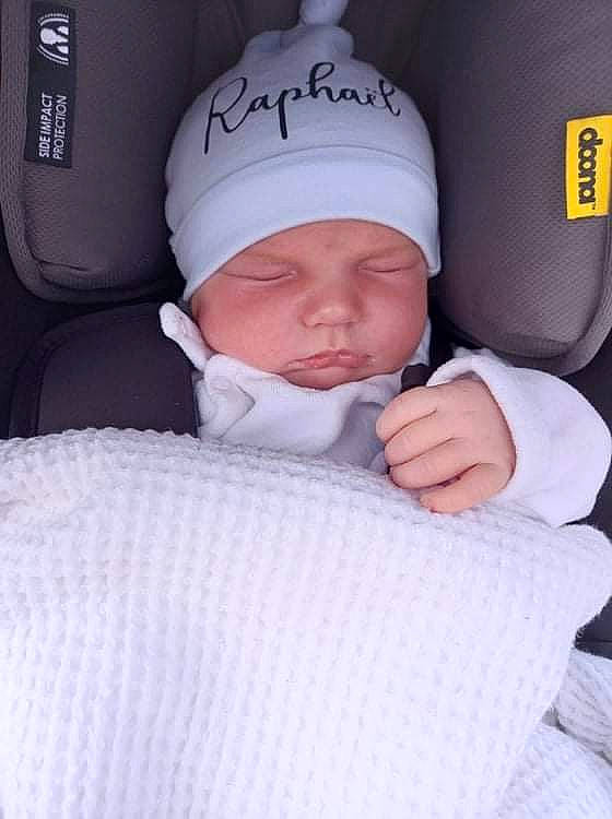 Raphaël a rejoint le concours — aidez-le/la à gagner de superbes lots ! baby, baby_in_car_seat, baby_products, baby_sleeping, baby_toddler_clothing, baseball_cap, beanie, cap, car_seat, car_seat_cover, cheek, child, comfort, finger, headwear, knit_cap, linens, person, sitting, sleeve