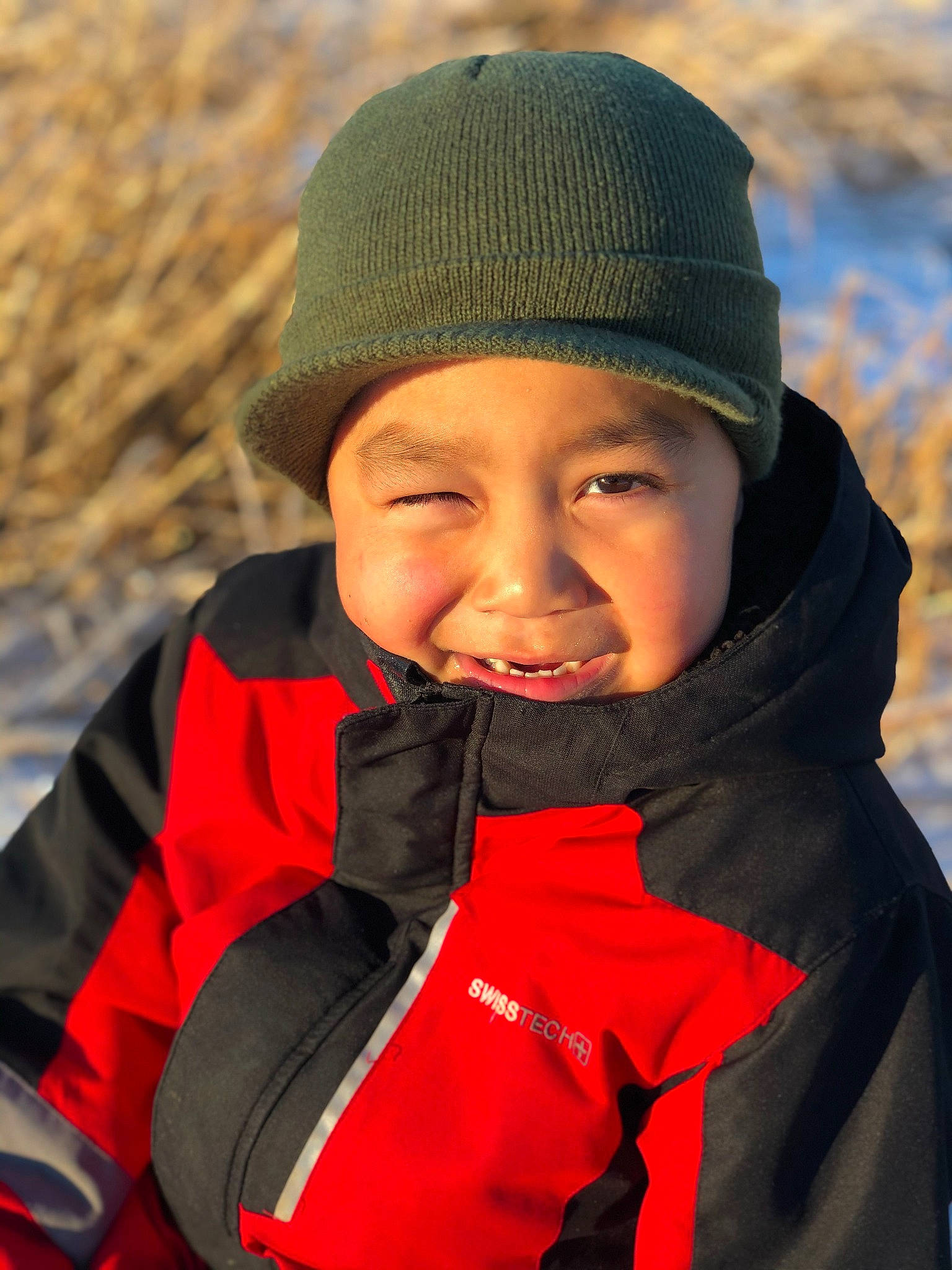 Isaiah is registered to the contest to win money with this photo: beanie, cap, child, electric_blue, fashion_accessory, freezing, fun, happy, headwear, jacket, knit_cap, landscape, outerwear, person, personal_protective_equipment, portrait_photography, smile, toddler, vacation, winter