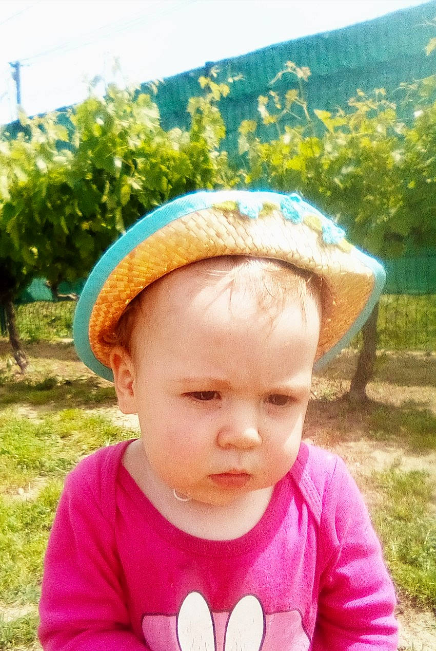 Kelly participe au concours pour gagner de l'argent avec cette photo : baby, baby_toddler_clothing, bonnet, cheek, child, costume_accessory, headgear, human, people_in_nature, person, pink, plantation, summer, sun_hat, toddler