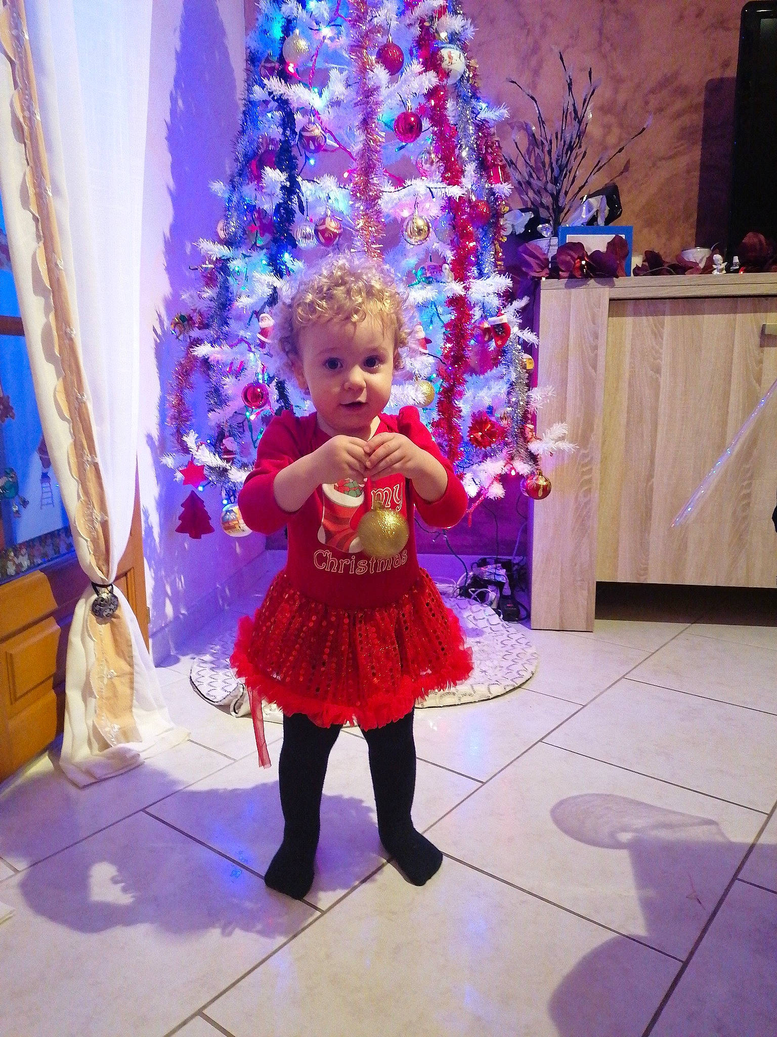 Kelly a rejoint le concours — aidez-le/la à gagner de superbes lots ! baby_toddler_clothing, christmas, christmas_decoration, christmas_tree, costume, costume_accessory, curtain, floor, flooring, fur, holiday, interior_design, magenta, one_piece_garment, ornament, person, pink, purple, toy, window_treatment