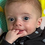 Theodore is registered to the contest to win money with this photo: baby, infant, face, blue_eyes, hand, fingers, clothing, pattern, hot_air_balloon, curious, closeup, portrait, child, cute, young, skin, mouth, expression, background, colorful