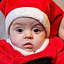 baby, child, face, portrait, red_clothing, santa_hat, holiday, costume, cute, infant, expression, eyes, closeup, christmas, festive, warm_clothing, indoors, person, headwear, soft_texture