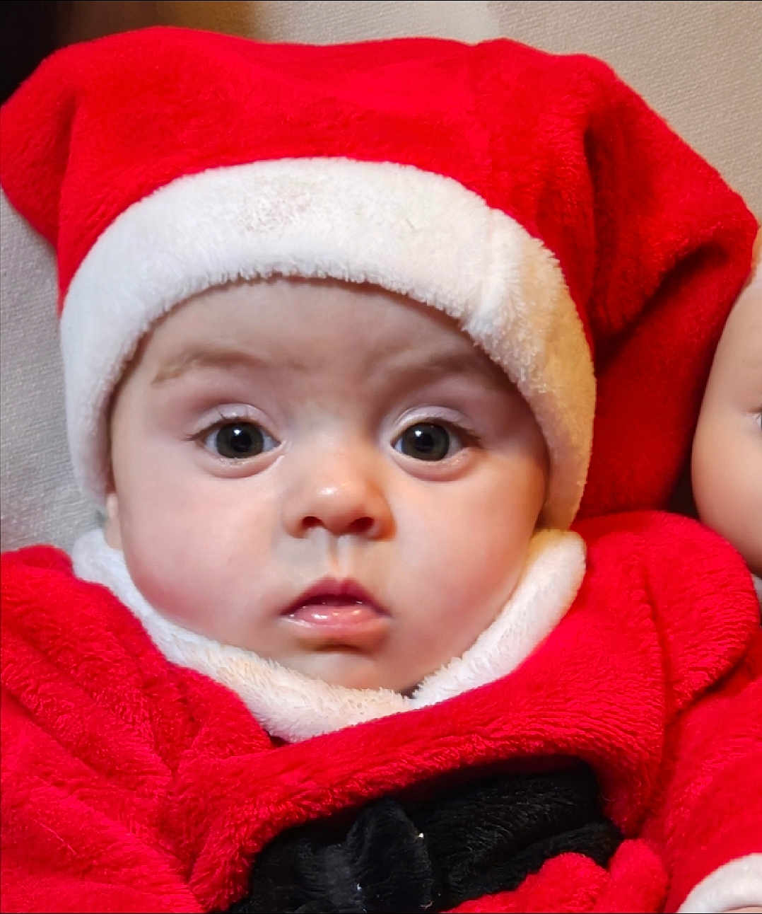 Mya participe au concours pour gagner de l'argent avec cette photo : baby, child, face, portrait, red_clothing, santa_hat, holiday, costume, cute, infant, expression, eyes, closeup, christmas, festive, warm_clothing, indoors, person, headwear, soft_texture