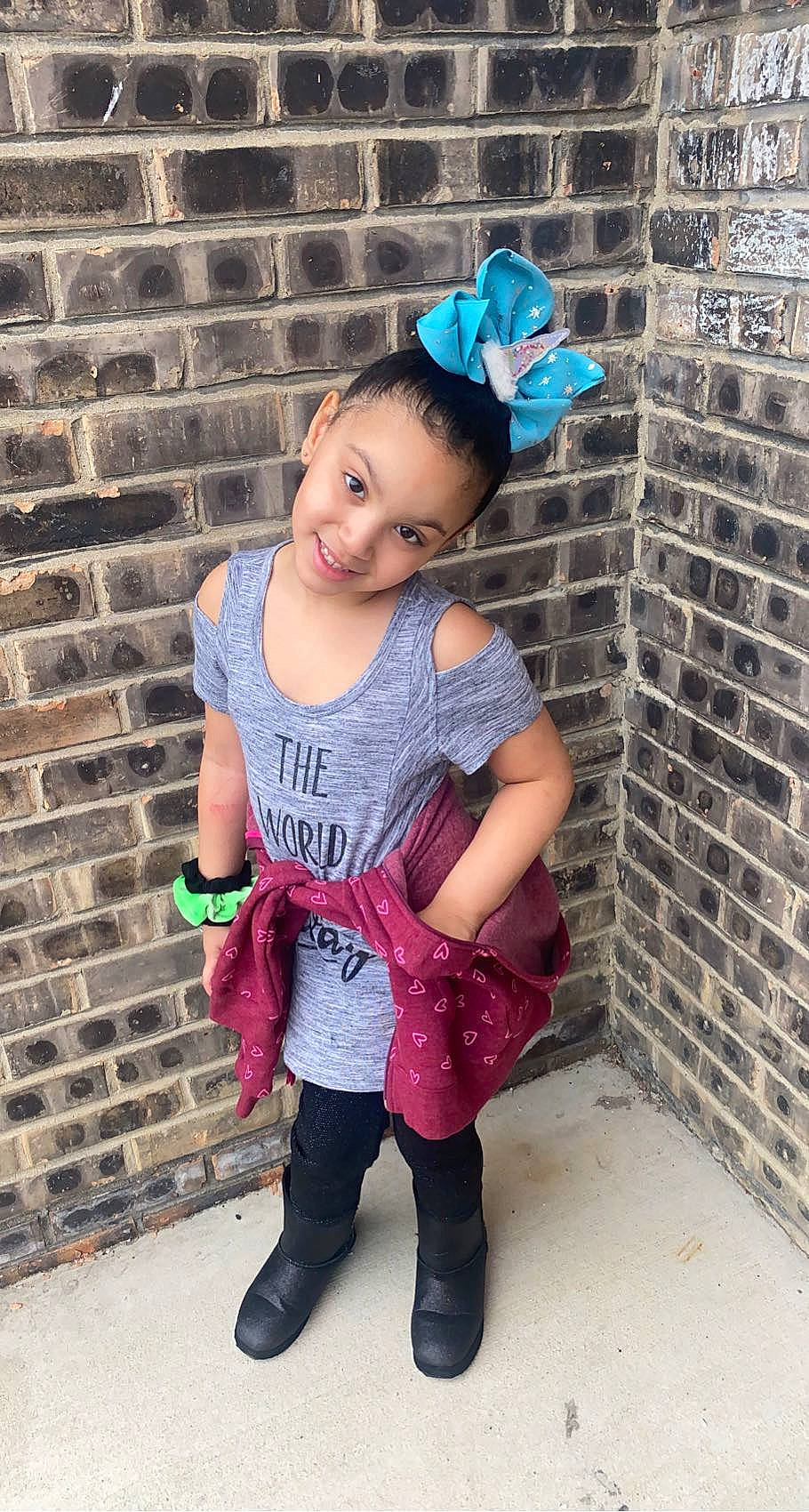 Lilianna is registered to the contest to win money with this photo: baby_toddler_clothing, blue, brick, brickwork, cool, face, happy, head, joy, knee, leg, magenta, person, pink, purple, shoulder, sleeve, standing, t_shirt, thigh