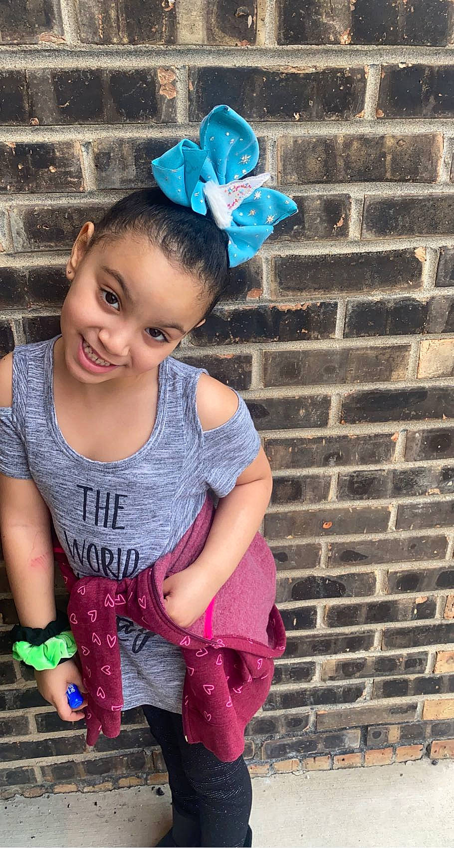 Lilianna is registered to the contest to win money with this photo: baby_toddler_clothing, blue, brick, brickwork, clothing, cool, electric_blue, green, hand, happy, hat, joy, magenta, pattern, person, pink, purple, sleeve, smile, standing