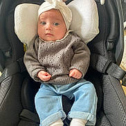 Camélia a rejoint le concours — aidez-le/la à gagner de superbes lots ! baby, black, blue, car_seat, child, clothing, comfort, cushion, cute, face, headwrap, indoor, infant, jeans, person, portrait, socks, sweater, toy, white