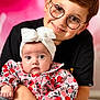 baby, boy, child, glasses, headband, holding, infant, portrait, smiling, cute, sitting, colorful_clothing, floral_pattern, indoor, family, love, happy, young, people, background_blur