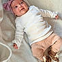 baby, infant, child, headband, bow, white_shirt, ribbed_clothing, pants, peach_color, leopard_print, booties, blanket, soft_texture, smiling, lying_down, cute, portrait, indoors, happy, person