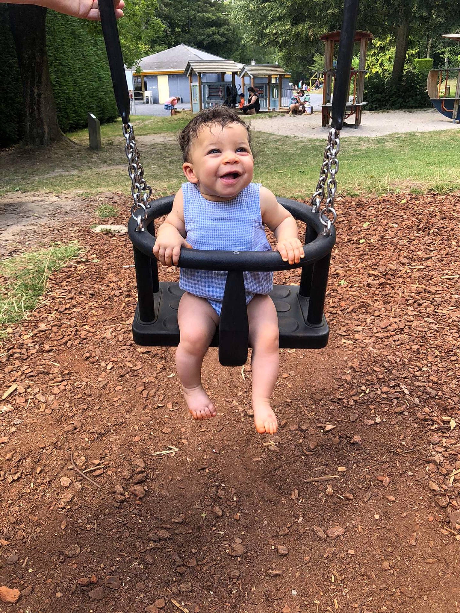 Aliya a rejoint le concours — aidez-le/la à gagner de superbes lots ! backyard, barefoot, child, fun, grass, leg, outdoor_play_equipment, person, plant, play, playground, public_space, recreation, sitting, smile, soil, summer, swing, toddler, tree