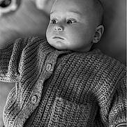 Léon participe au concours pour gagner de l'argent avec cette photo : baby, infant, knitwear, cardigan, portrait, face, child, cozy, soft_lighting, black_and_white, clothing, texture, hand, expression, blurred_background, indoors, cute, young, newborn, peaceful