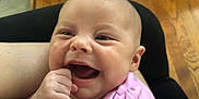 Willow is registered to the contest to win money with this photo: baby, child, infant, smiling, happy, pink_shirt, hand, indoor, floor, slippers, bottle, wooden_floor, person, face, portrait, cute, sitting, joy, skin, closeup