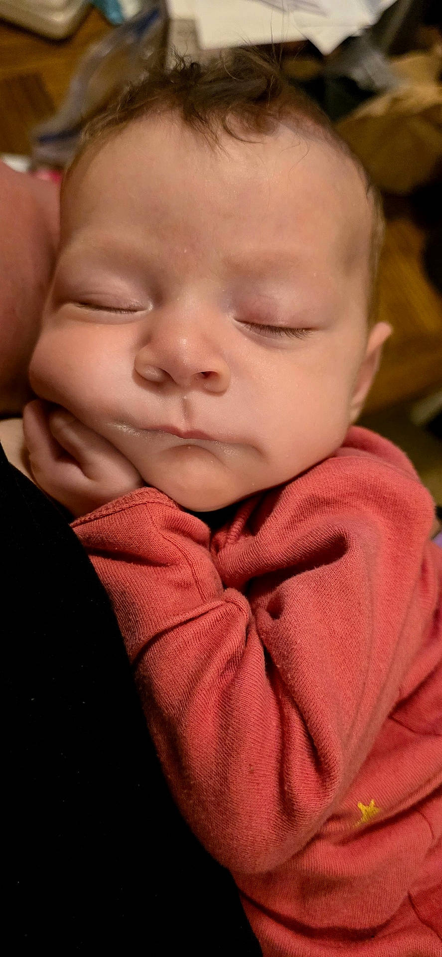 Jaceyn is registered to the contest to win money with this photo: baby, close_up, coral_outfit, cozy, cradled, cute, face, hands, home, indoors, infant, long_sleeves, newborn, peaceful, photography, portrait, resting, sleeping, sleepy, warm_lighting