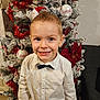 Lucas participe au concours pour gagner de l'argent avec cette photo : bauble, bow_tie, boy, child, christmas_tree, couch, eyes, festive, frosted_tree, happy, holiday, indoor, ornament, poinsettia, portrait, red_decorations, short_hair, smiling, tinsel, white_shirt