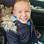 boy, car_seat, casual_clothing, child, coat, eyes, fur_hood, hair_spikes, happy, interior, jacket, portrait, seat, sitting, smile, smiling, teeth, vehicle, window, young_child